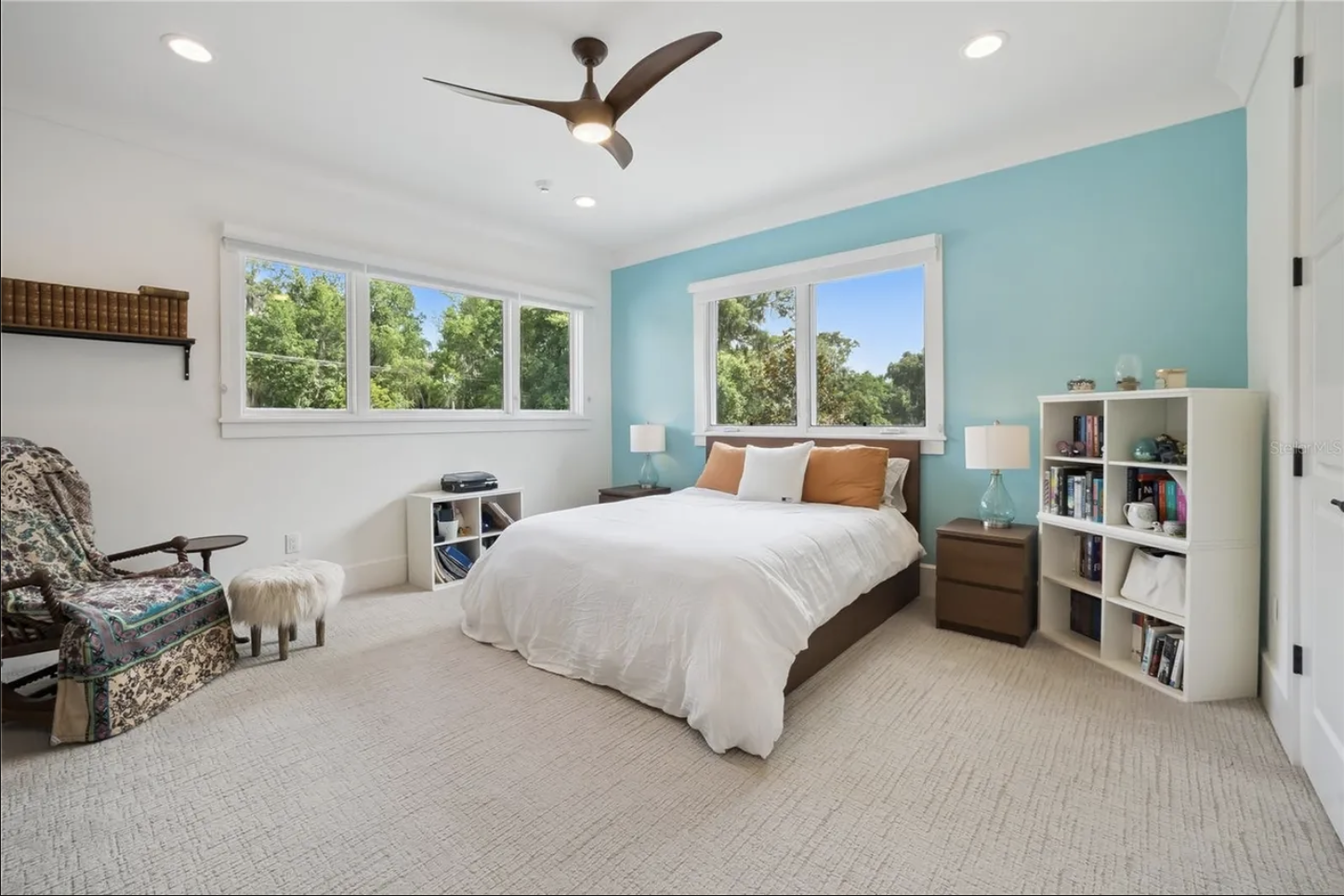 Bedroom with teal accent wall and treetop views