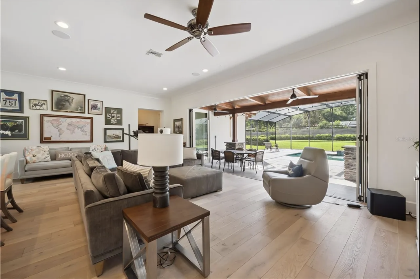Living room with sliding doors open to the covered lanai and pool