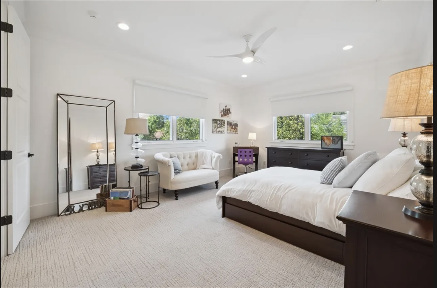 Guest bedroom with settee, floor mirror, and dual windows