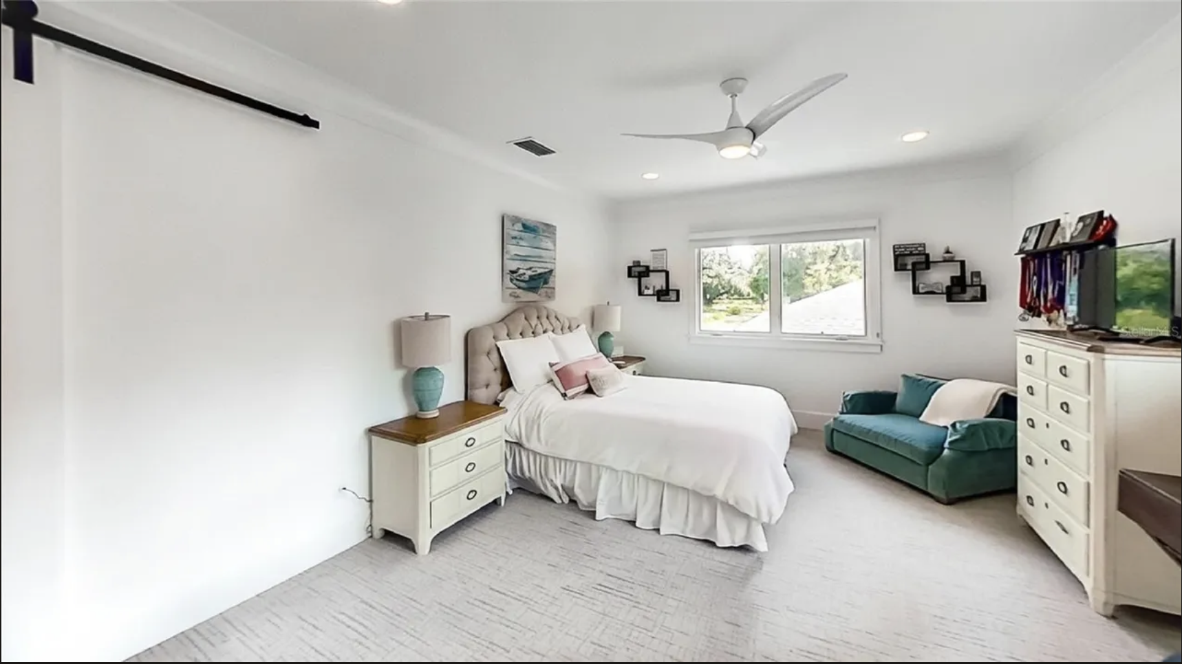 Bedroom with barn door track and window seating area