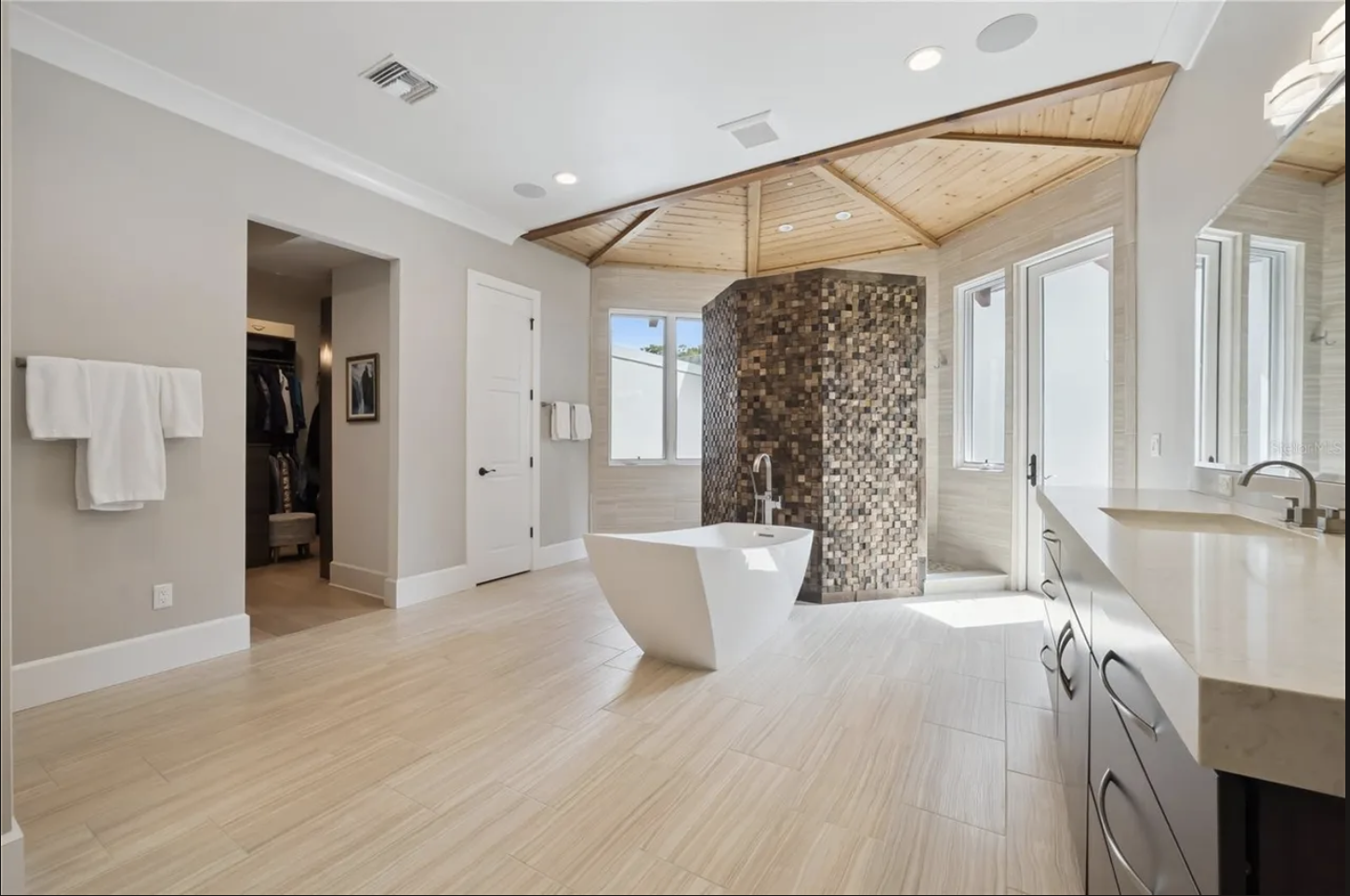 Primary bath with freestanding tub and mosaic-tiled walk-in shower